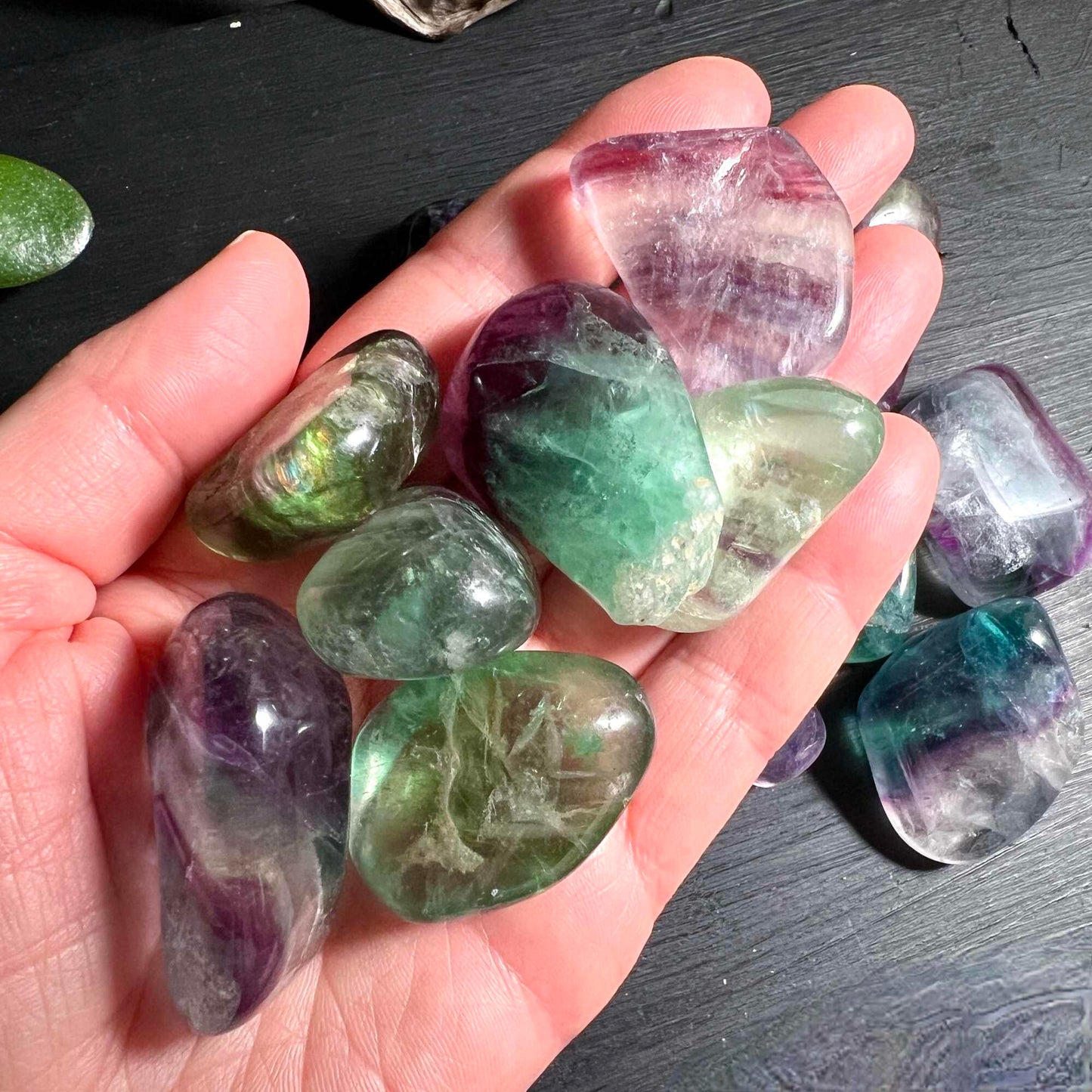 Regenbogenfluorit Trommelsteine XL in der Hand zur Größenveranschaulichung