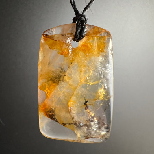Goldener Heiler | freihängend | grauem Hintergrund | transparentes Innenleben | feuriges Orange | Happy Minerals