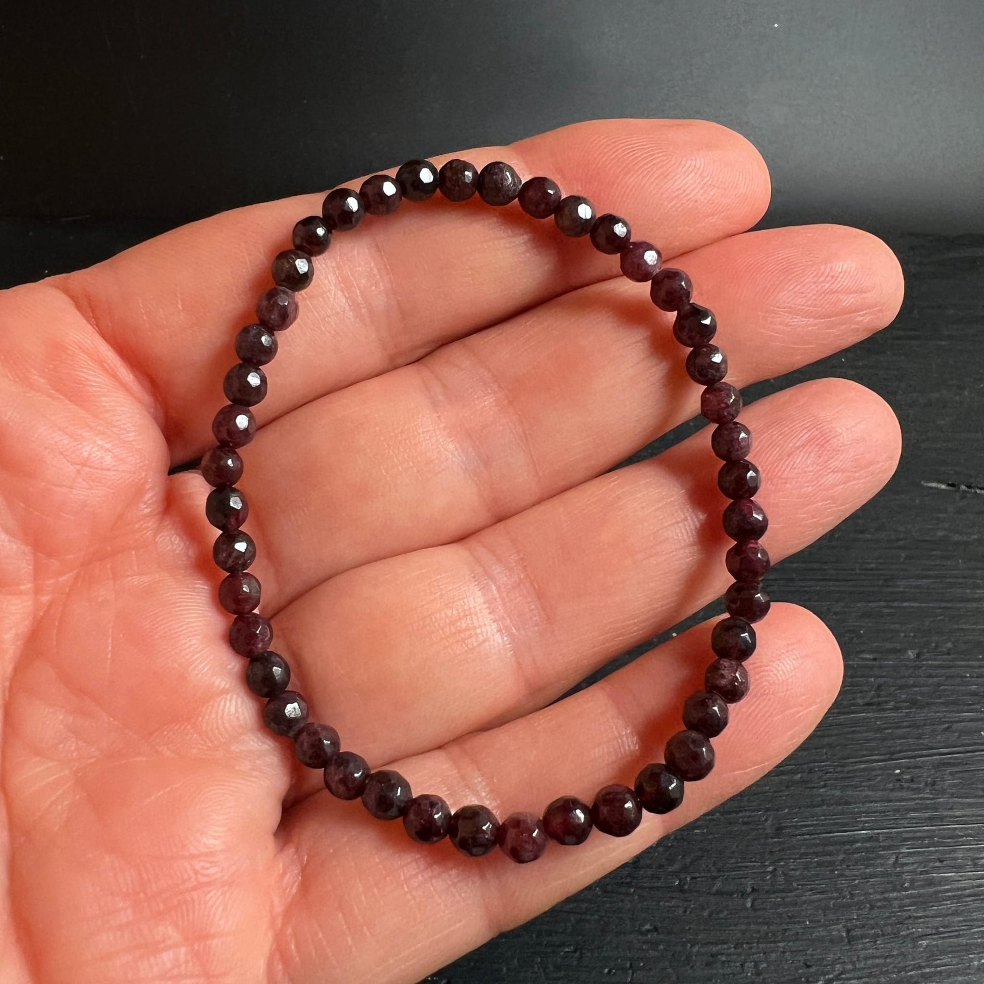 Granat Armband | Almandin dunkelrot | facettierte Kugeln | in Handfläche liegend | Happy Minerals