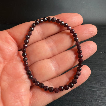 Granat Armband | Almandin dunkelrot | facettierte Kugeln | in Handfläche liegend | Happy Minerals