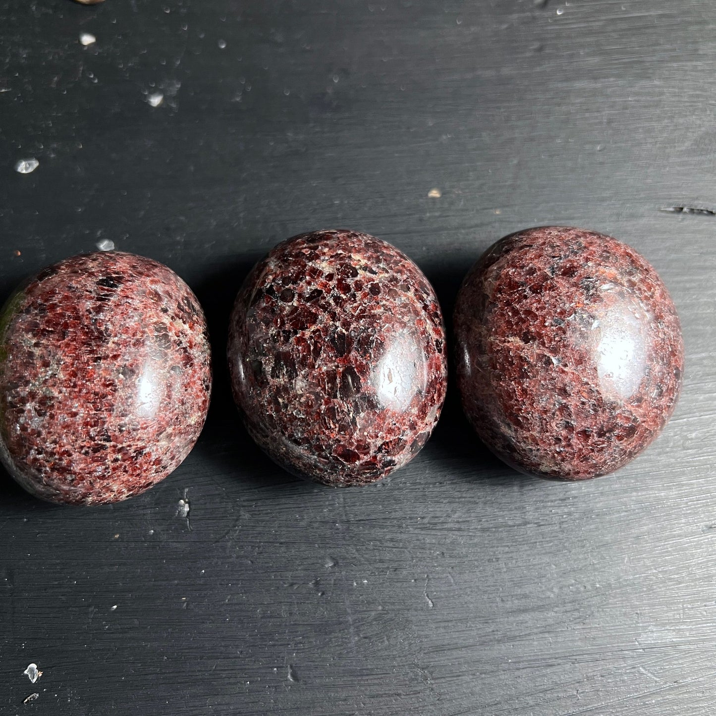 Granat Almandin Trio | polierte Steine | weinrote Kristalleinschlüsse | dunkler Holzhintergrund | Happy Minerals