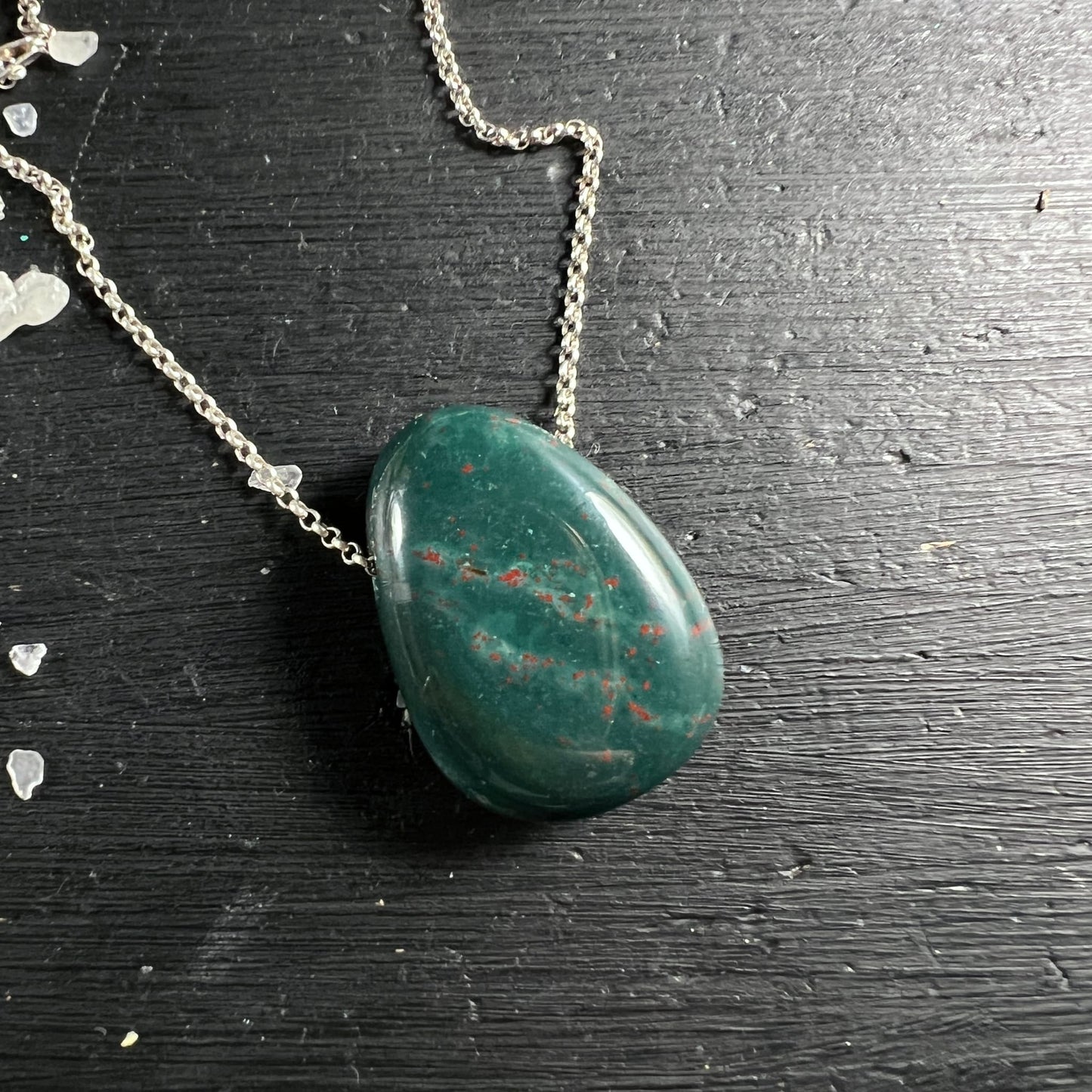 Heliotrop Blutstein | Seitenansicht | silberne Kette | schwarze Oberfläche | Tropfen | Happy Minerals