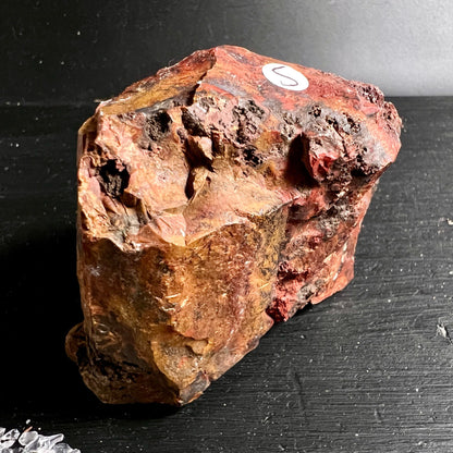 Heliotrop Rohstein mit rostrot-ockerfarbener Oberflaeche, poroesen Vertiefungen und rauer Bruchkante | Happy Minerals