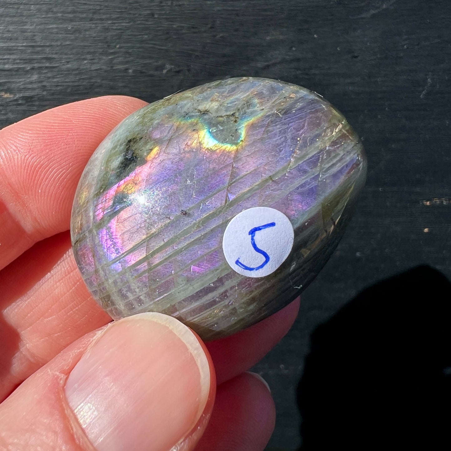Labradorit Handschmeichler oval mit violett-goldenem Farbspiel in Hand gehalten | Happy Minerals