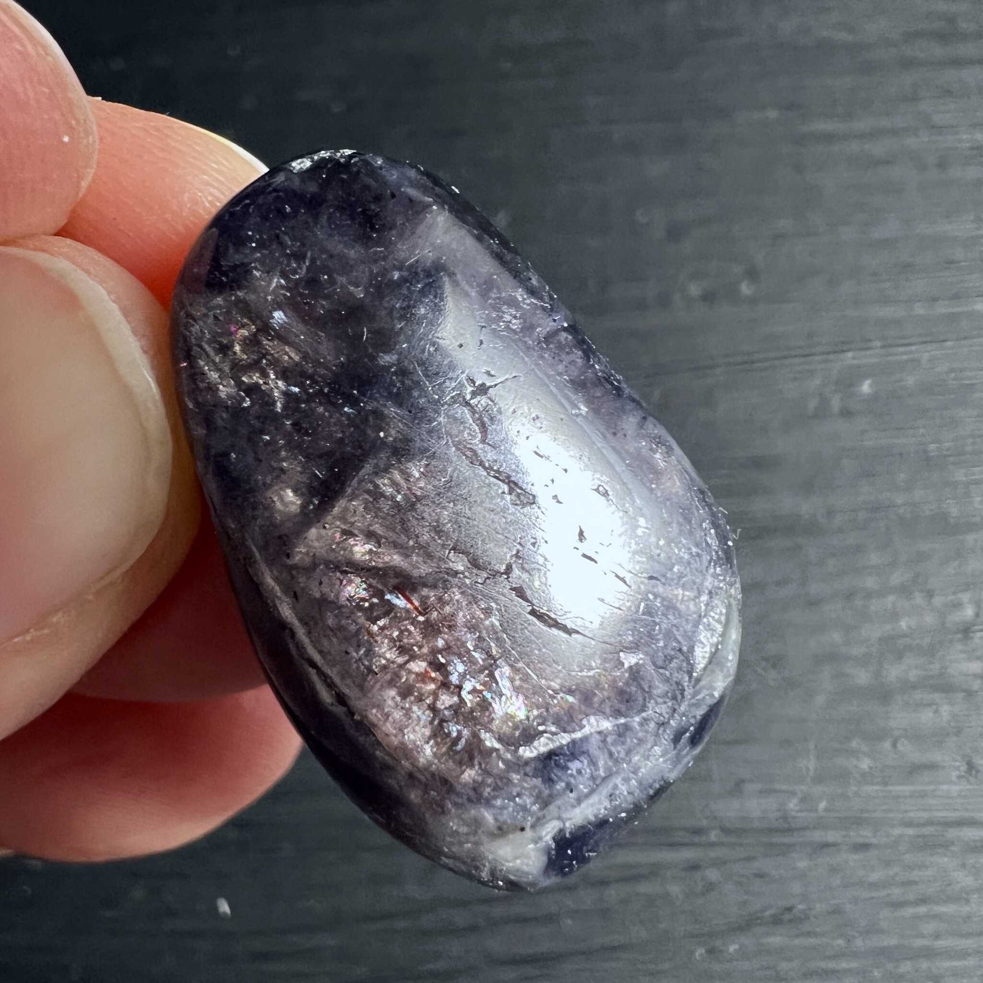 Tiefvioletter Iolith Anhänger mit goldenen Sonnenstein-Glitzern auf dunklem Holz | Happy Minerals