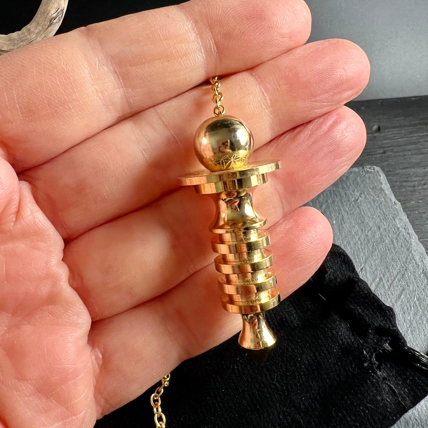Isis Pendel Messing vergoldet | in der Hand gehalten | Größenvergleich | Spiralringe & Kugelkopf | Happy Minerals
