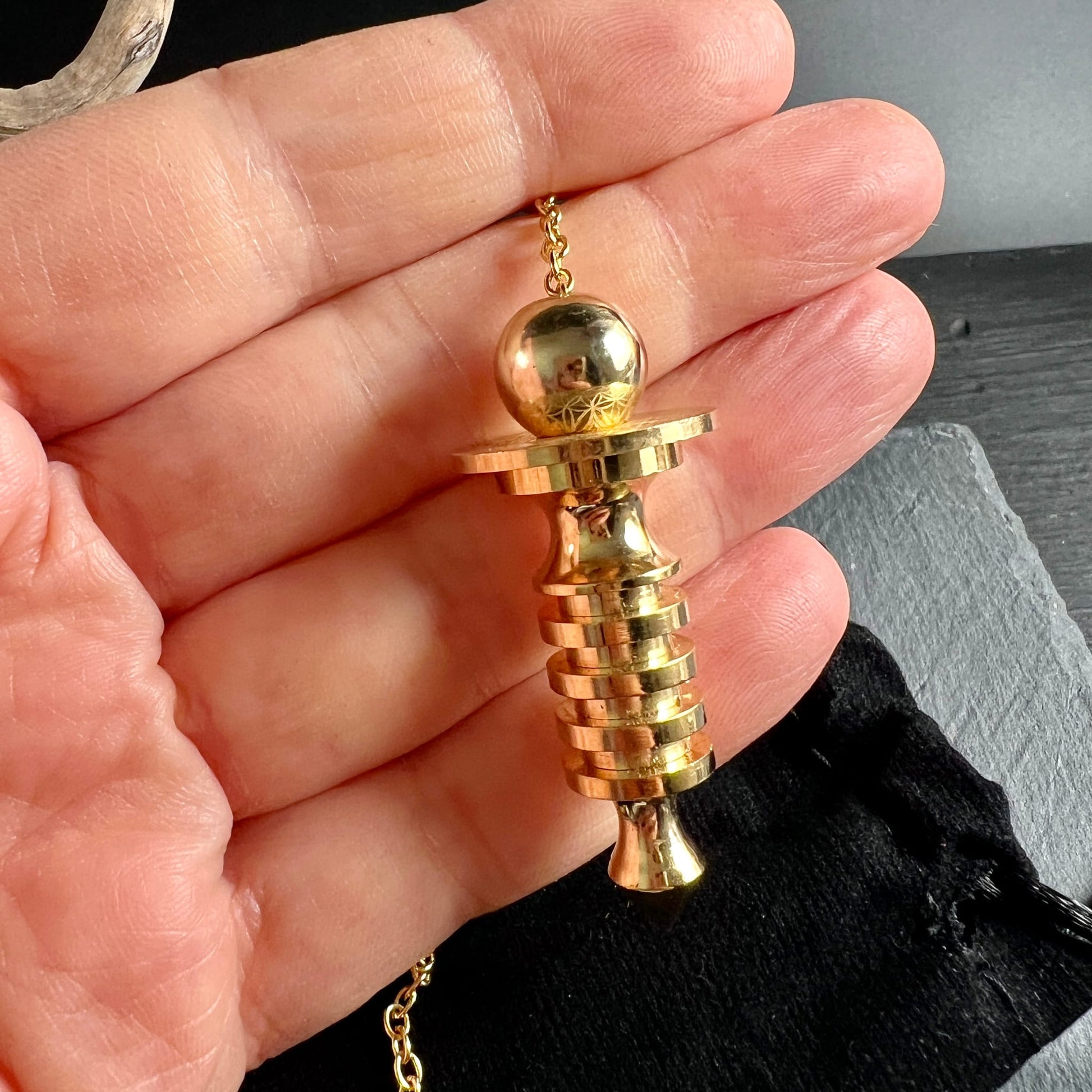 Isis Pendel Messing vergoldet | in der Hand gehalten | Größenvergleich | Spiralringe & Kugelkopf | Happy Minerals