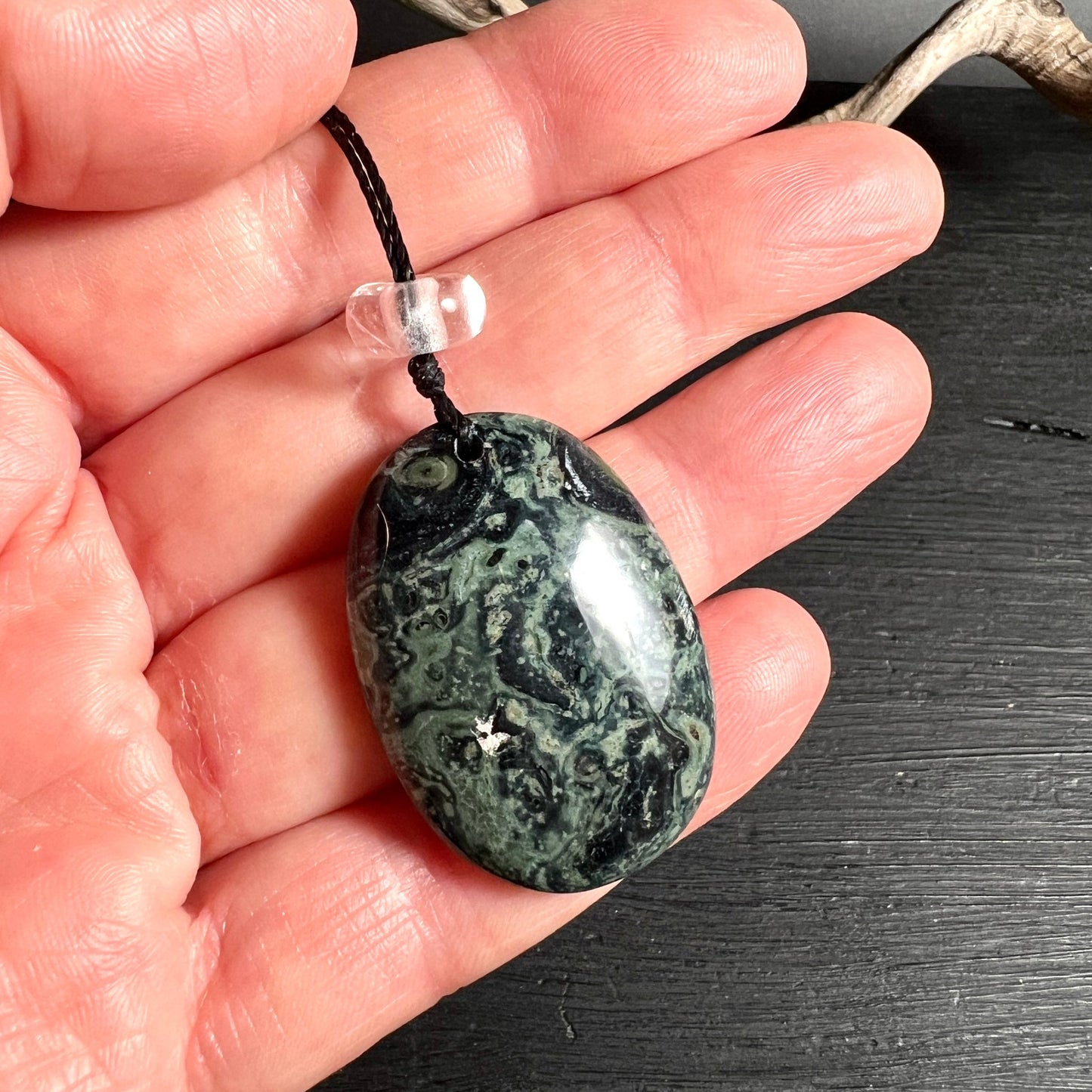 Kambaba Jaspis | Hand zeigt Größe | Bergkristall Perle | dunkelgrüne Kreise | polierte Oberfläche | Happy Minerals