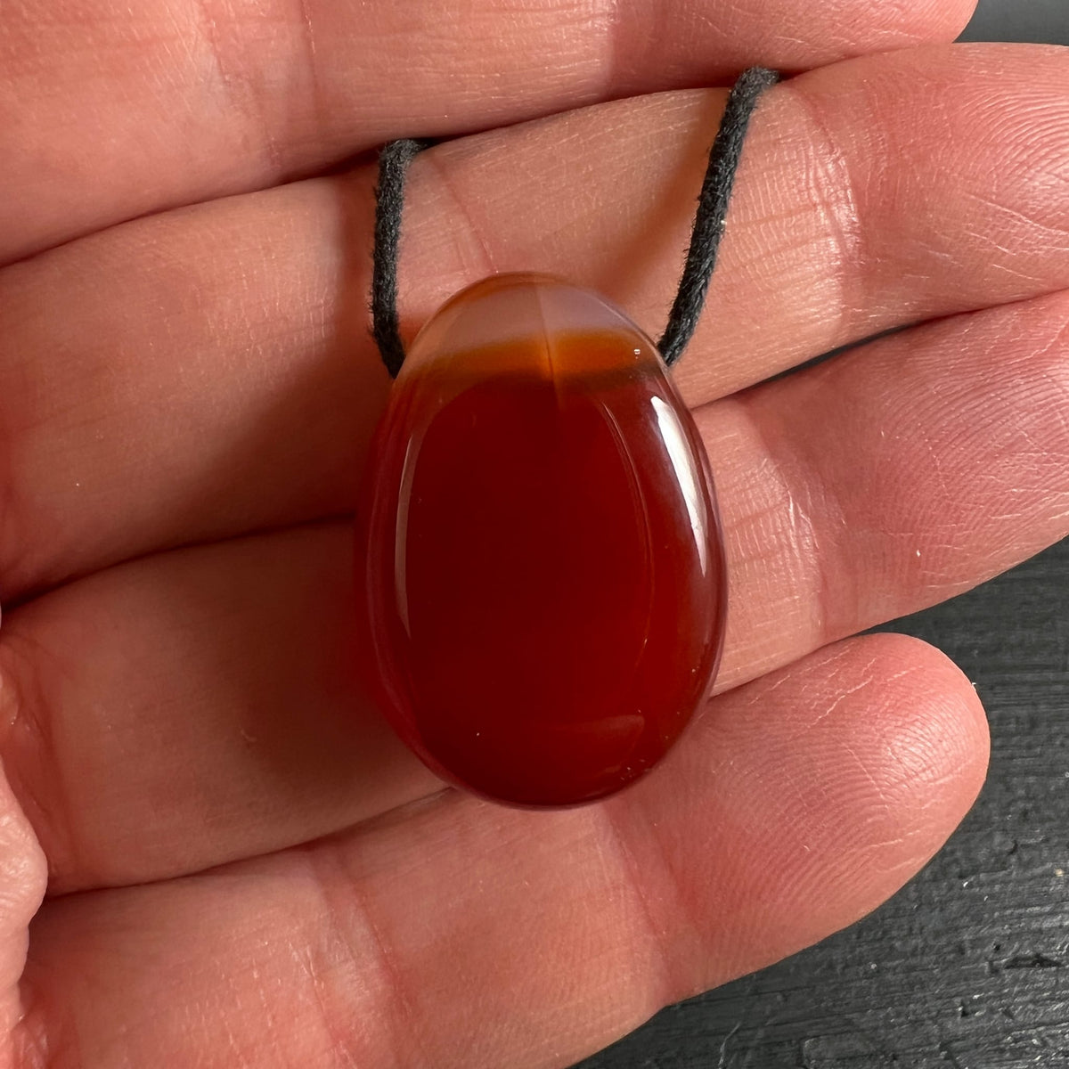 Karneol Anhänger | in Hand gehalten | warmes Rotorange | Naturstein | Happy Minerals