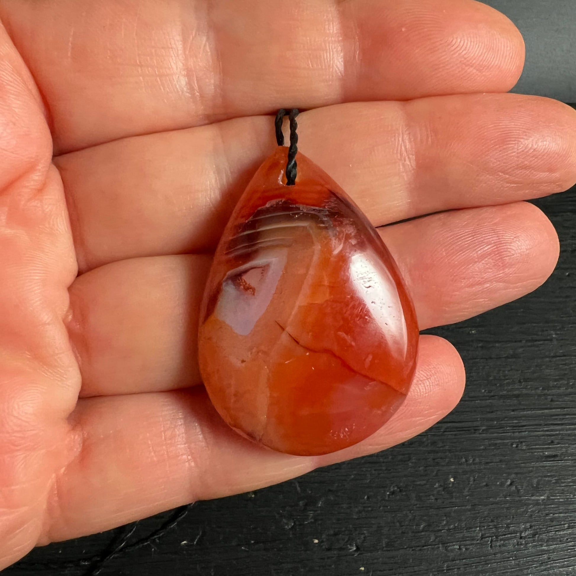 Karneol | in der Hand | Größenvergleich | Tropfenschliff | Happy Minerals