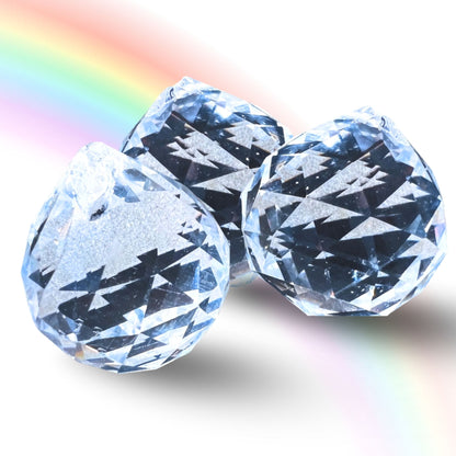 Drei facettierte klare Kristallkugeln 30mm mit Diamantschliff, Regenbogenlicht-Reflexion im Hintergrund | Happy Minerals