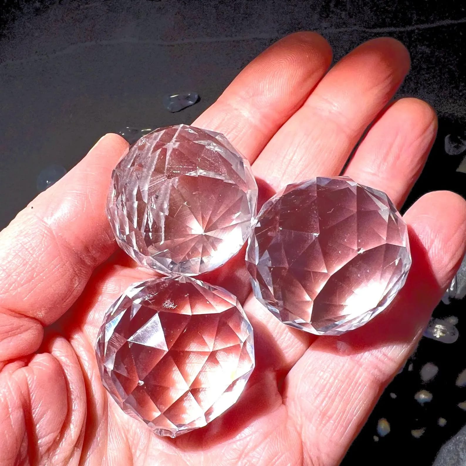 Drei Kristallkugeln in Hand gehalten | schimmernde Glasfacetten | Happy Minerals | Variante C