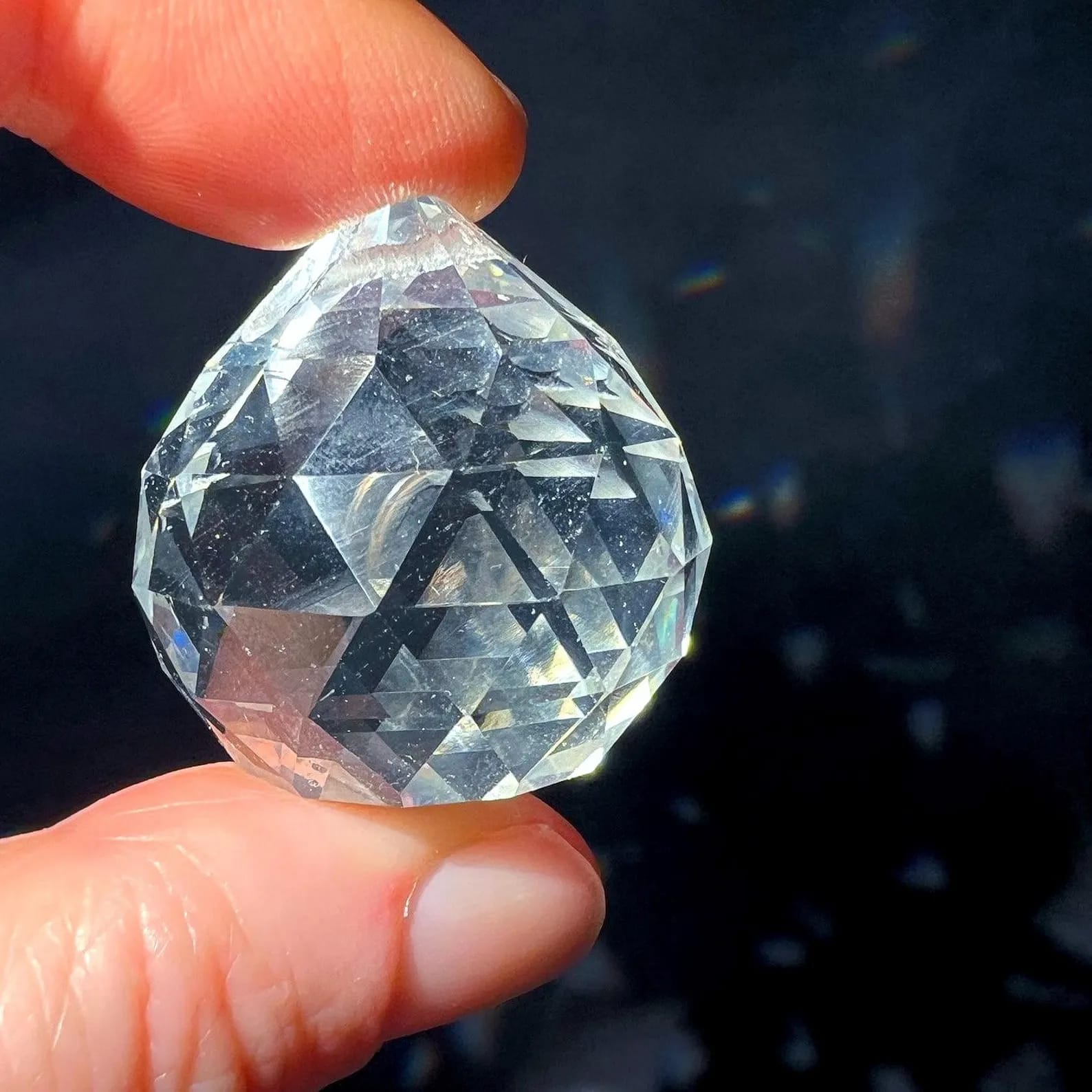 Einzelne Facettenkugel zwischen Fingern | glitzernder Glaskristall | Happy Minerals | Variante D