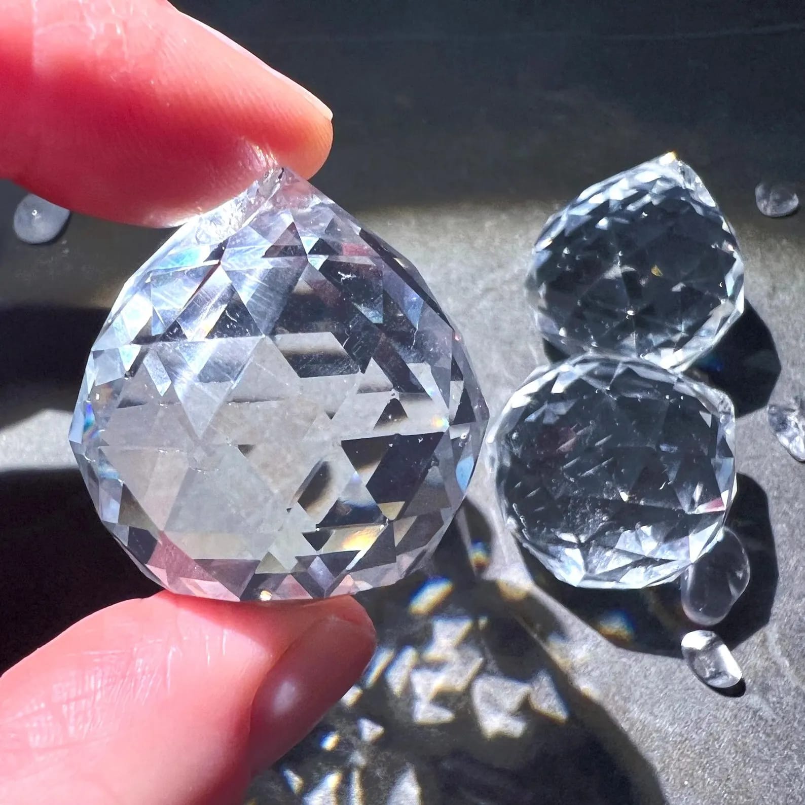 Kristallkugel im Sonnenlicht | funkelnde Facetten | zwei weitere im Hintergrund | Happy Minerals | Variante E