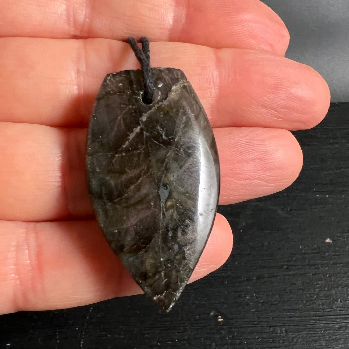 Labradorit Anhänger blattförmig, dunkelgrau mit silbrigem Glanzbereich, raue Oberfläche mit polierten Zonen | Happy Minerals