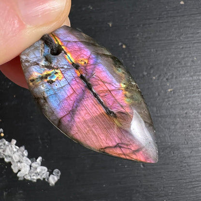 Labradorit Anhänger tropfenform poliert, violett-pink-blau Labradoreszenz, orange-gelbe Lichtreflexe, schwarze Einschlüsse | Happy Minerals