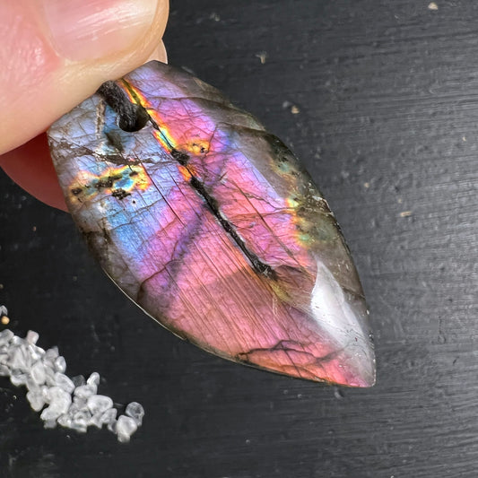Labradorit Anhänger tropfenform poliert, violett-pink-blau Labradoreszenz, orange-gelbe Lichtreflexe, schwarze Einschlüsse | Happy Minerals