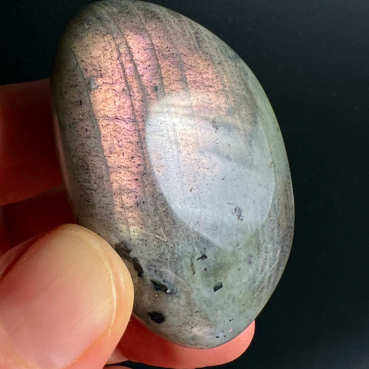 Labradorit Handschmeichler oval-poliert, grau-grüner Grundton mit rosafarbenem Labradoreszenz-Schimmer, dunkle Einschlüsse | Happy Minerals