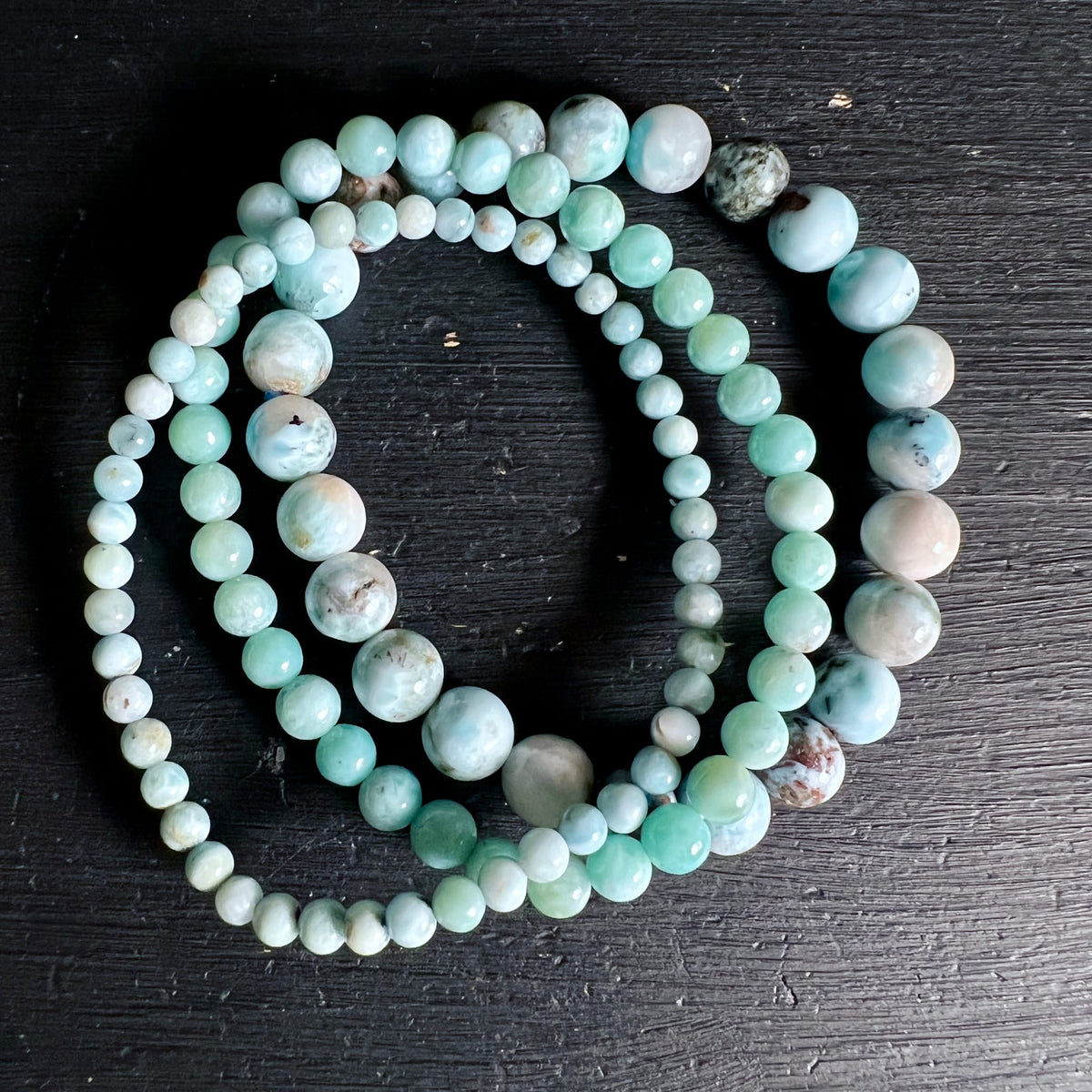 Larimar Armbaender aus runden Perlen in meerblau-tuerkis mit weissen und braunen Marmorierungen, hochglaenzend poliert | Happy Minerals