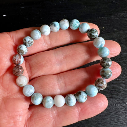 Larimar Armband aus runden Perlen, weiss-tuerkis marmoriert mit braunen Einschluessen, auf Hand | Happy Minerals