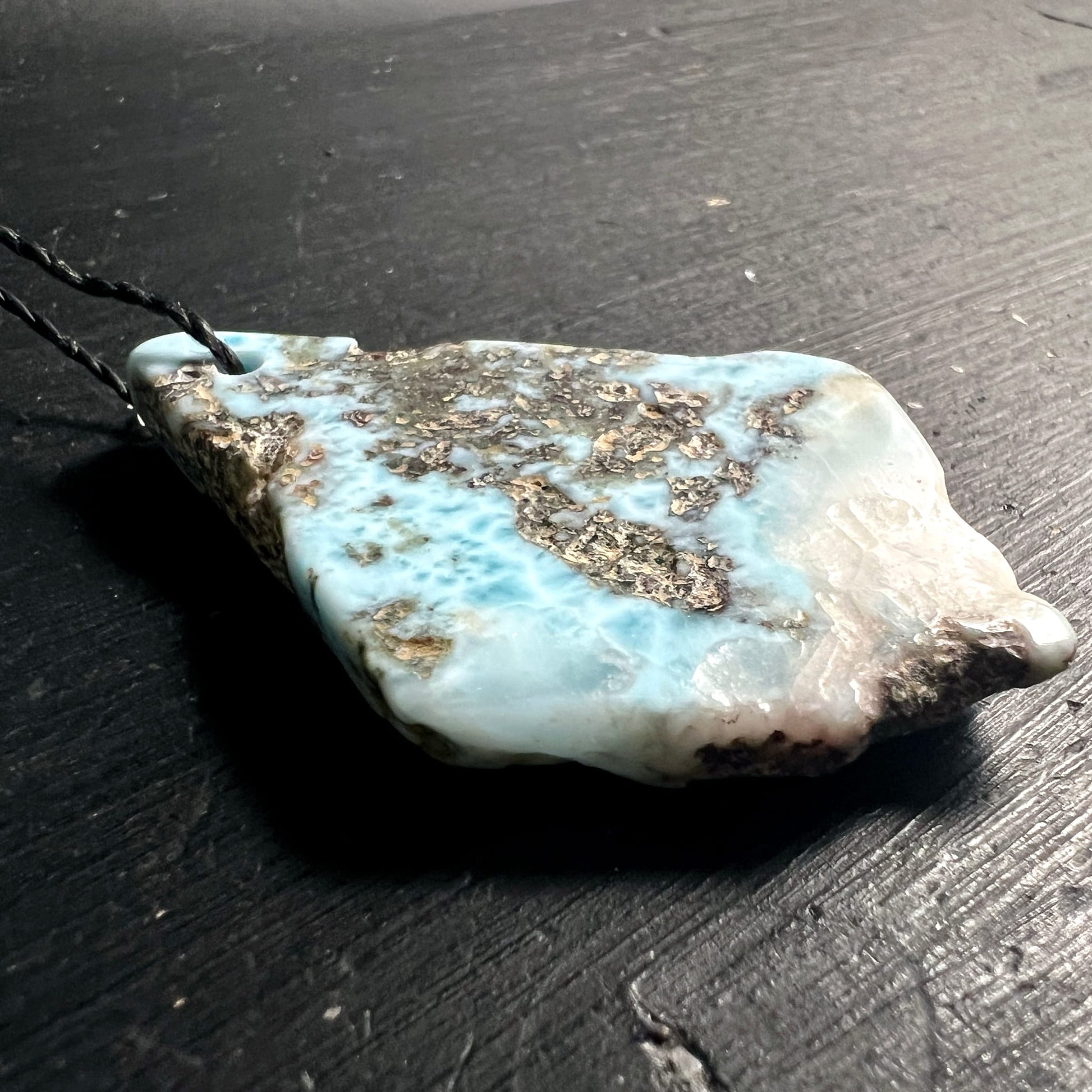 Larimar | Liegend | Dunkles Holz | Seitenansicht | Wolkige Struktur | Happy Minerals