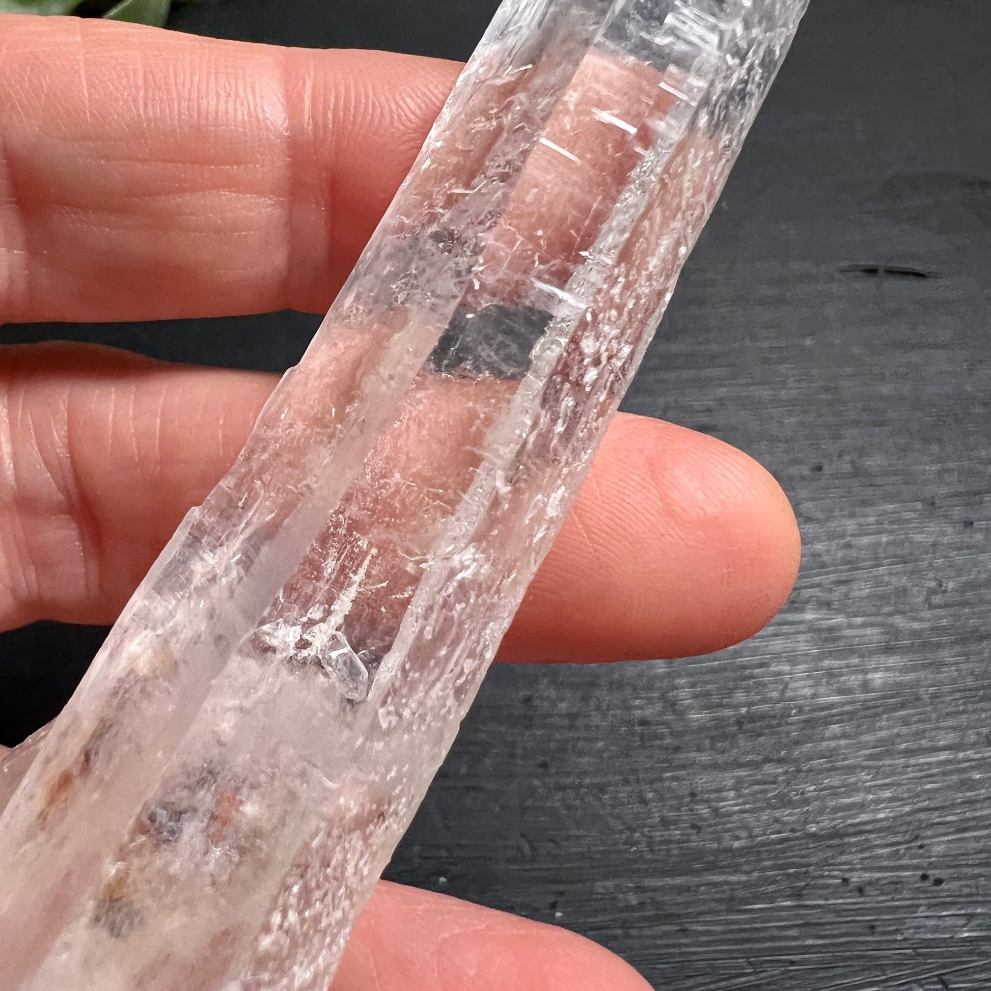 Lemuria Quarz Doppelender | Detailansicht Körper mit Hand | rötliche Phantomzonen innen | Happy Minerals