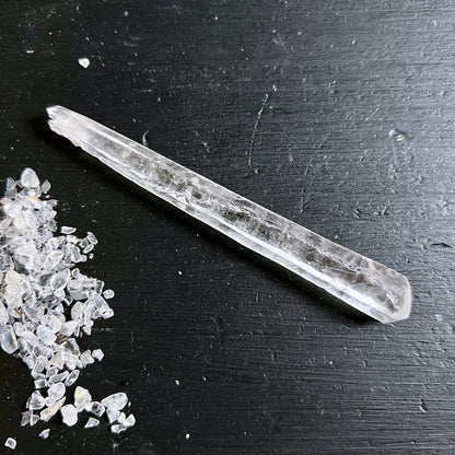Lemurian Quarz Doppelender, klar-transparenter Stab mit feinen Riefen und Leitern, auf schwarzem Holz | Happy Minerals