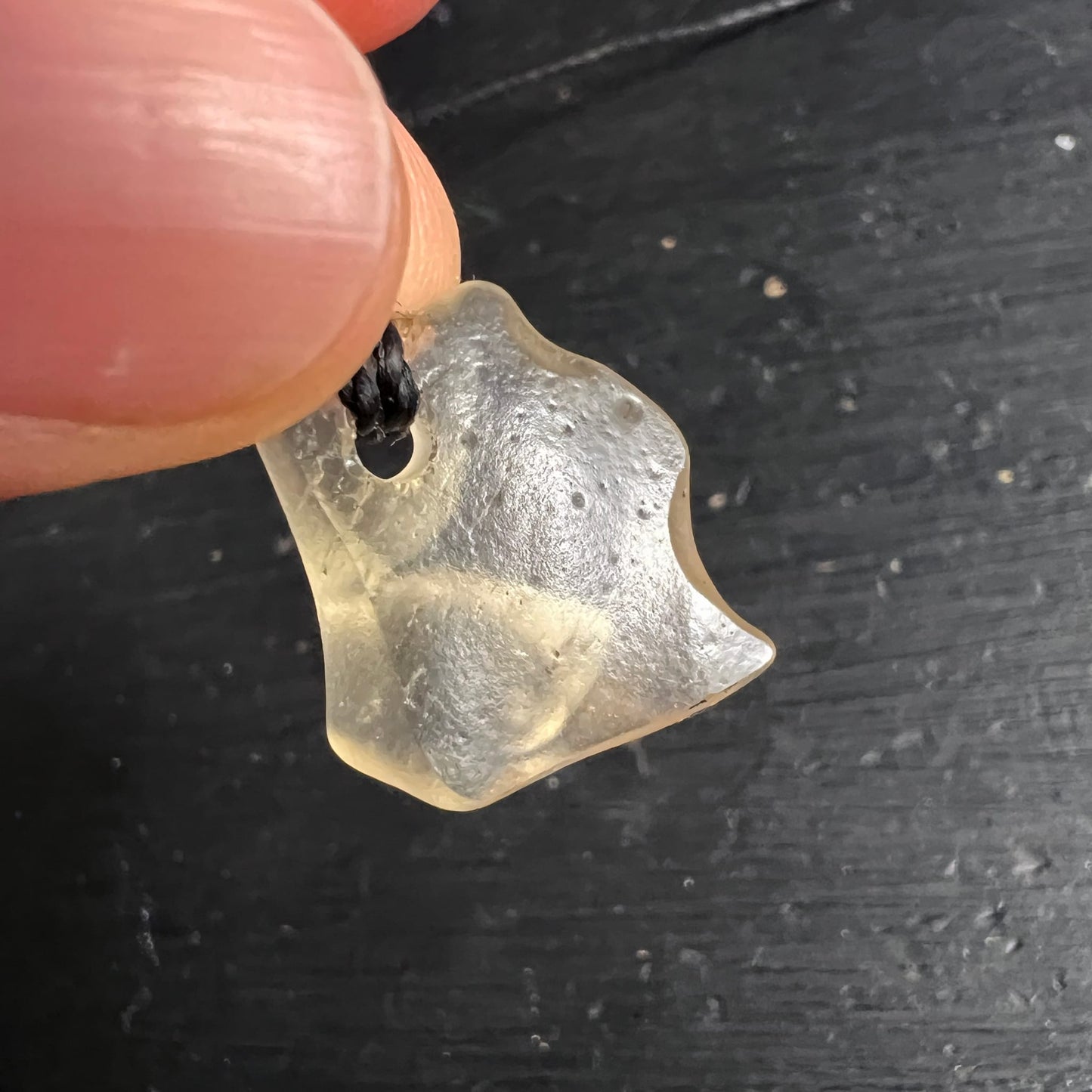 Libysches Glas Nahaufnahme | fein strukturierte Oberfläche | zwischen Fingern gehalten | Happy Minerals