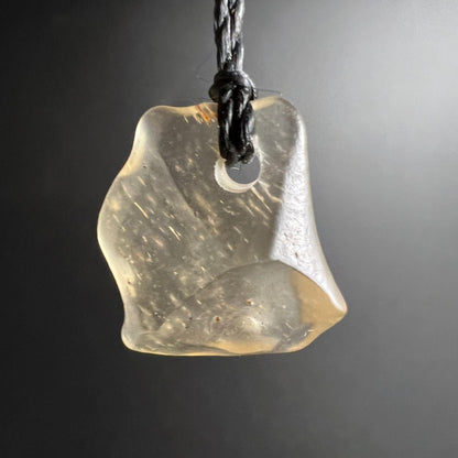 Libysches Glas hängend | freigestellt vor grauem Hintergrund | warmes Gelbgold | Happy Minerals