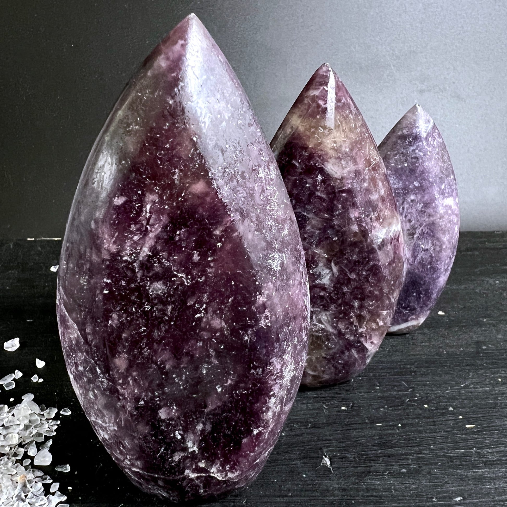 Lithium Lepidolith Flammen Trio | tief violett | Reihe auf dunklem Grund | Madagaskar | Happy Minerals | Variante 3