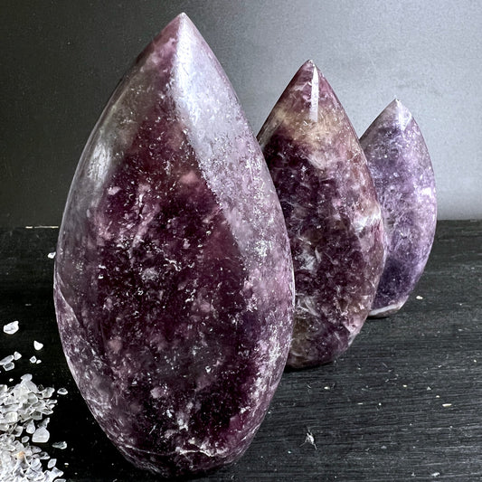 Lithium Lepidolith Flammen Trio | tief violett | Reihe auf dunklem Grund | Madagaskar | Happy Minerals | Variante 3