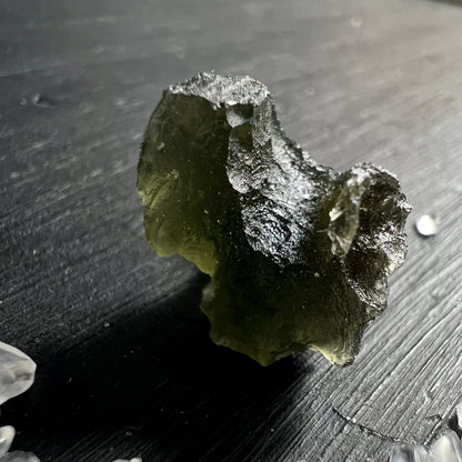 Moldavit Rohstein olivgruen mit silbrig glaenzender Schmelzkruste und zerklüfteter Oberflaeche | Happy Minerals