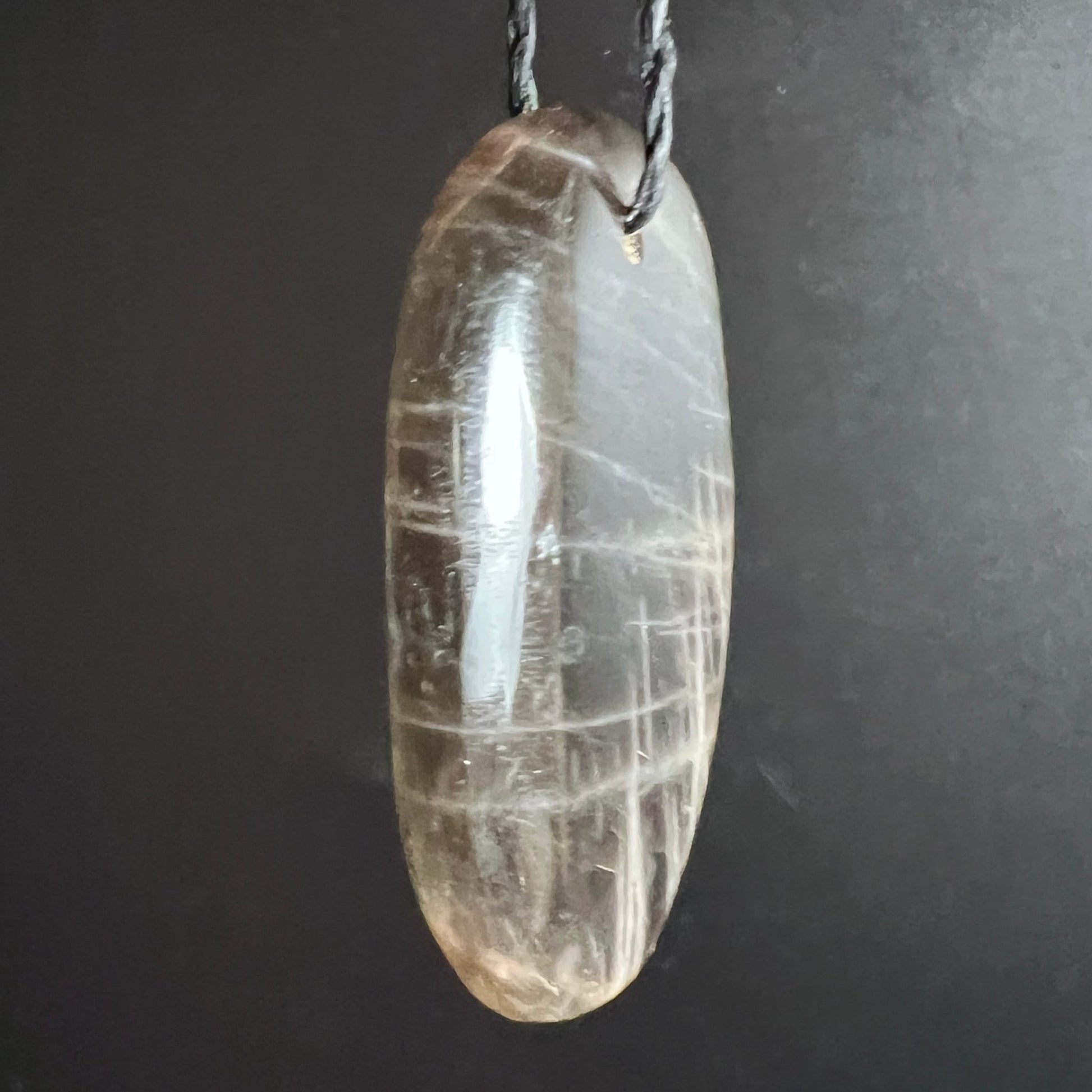 Mondstein Anhaenger oval poliert, transparent-grau mit weissen Gitterlinien und starkem Glanz | Happy Minerals