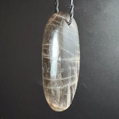Mondstein Anhaenger oval poliert, transparent-grau mit weissen Gitterlinien und starkem Glanz | Happy Minerals