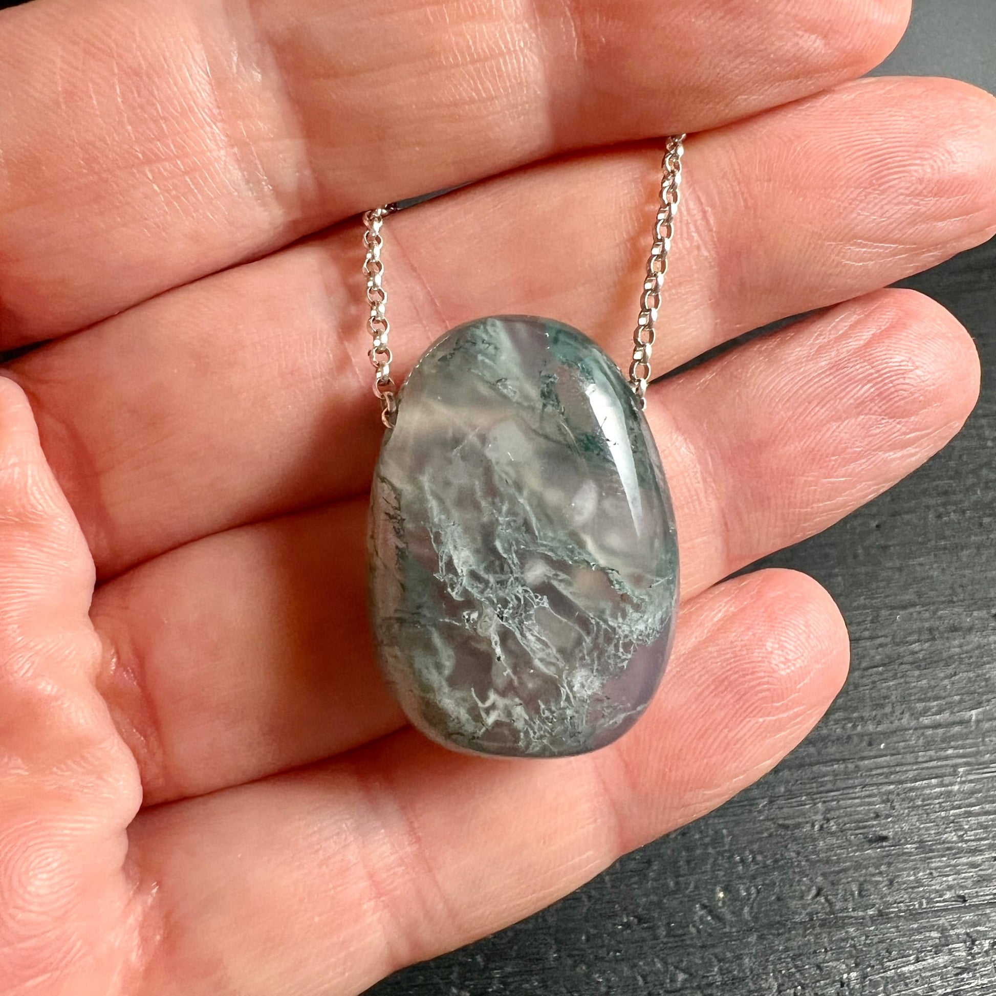 Moosachat Unikat | Brasilien | in der Hand | Größenvergleich | Silberkette | grau-grüne Nuancen | natürlicher Glanz | Happy Minerals