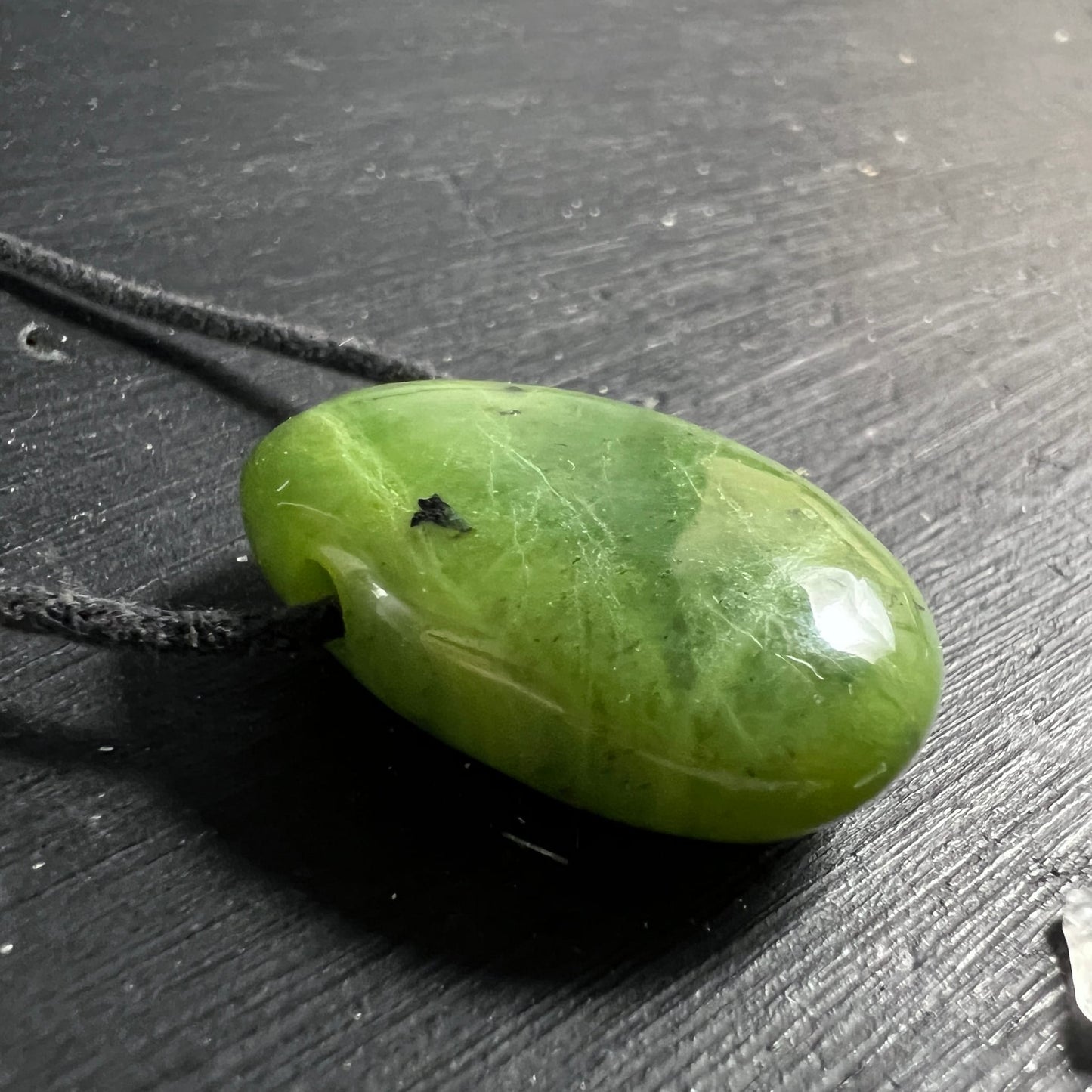 Nephrit Jade Anhaenger, glaenzend olivgruen mit feinen weissen Adern und dunklem Einschluss, ovale Tropfenform | Happy Minerals