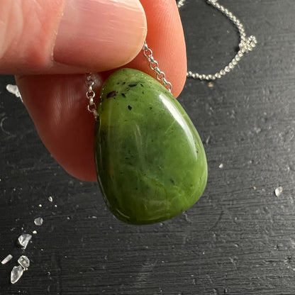 Nephrit Jade Kanada | zwischen Fingern gehalten | beide Seiten sichtbar | apfelgrün | Silberkette | Happy Minerals