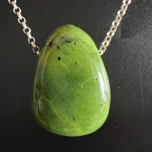 Nephrit Jade Kanada | Nahaufnahme Draufsicht | Silberkette | leuchtend gelbgrün | schwarze Einschlüsse | Happy Minerals