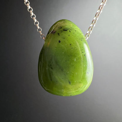 Nephrit Jade Kanada | hängend an Silberkette | sattes Grün | Lichtreflex | grauer Hintergrund | Happy Minerals
