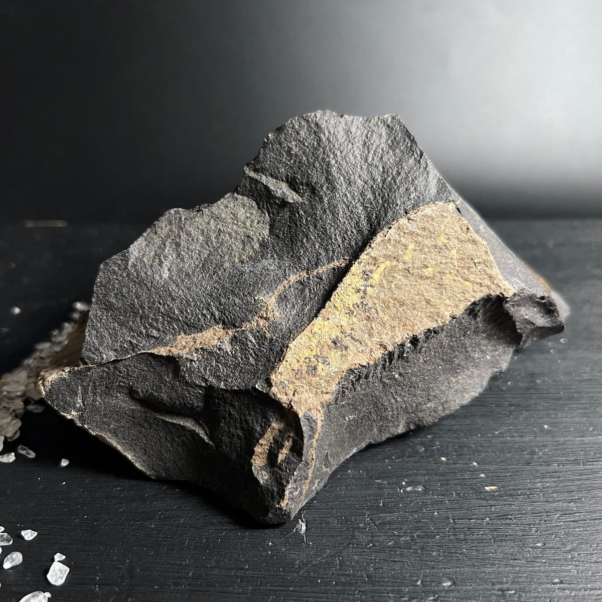 Roher Onyx Stein mit dunkelgrauer rauer Textur und ockerfarbenem Mineralband, kantige Bruchform | Happy Minerals