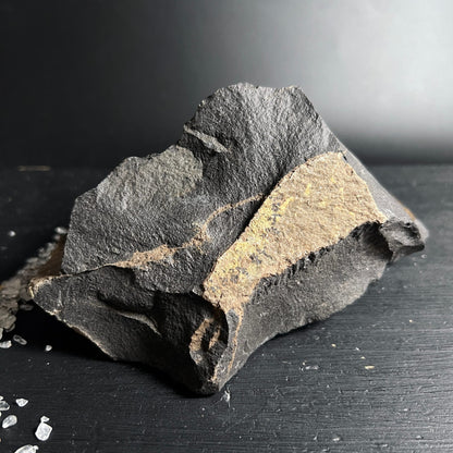 Roher Onyx Stein mit dunkelgrauer rauer Textur und ockerfarbenem Mineralband, kantige Bruchform | Happy Minerals