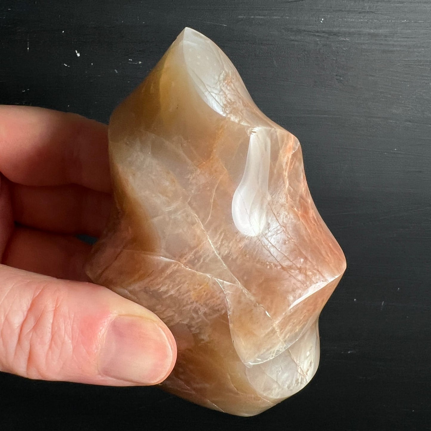 Orange Mondstein Flamme | in der Hand | transparente Schleier | honiggelbe Zonen | Happy Minerals