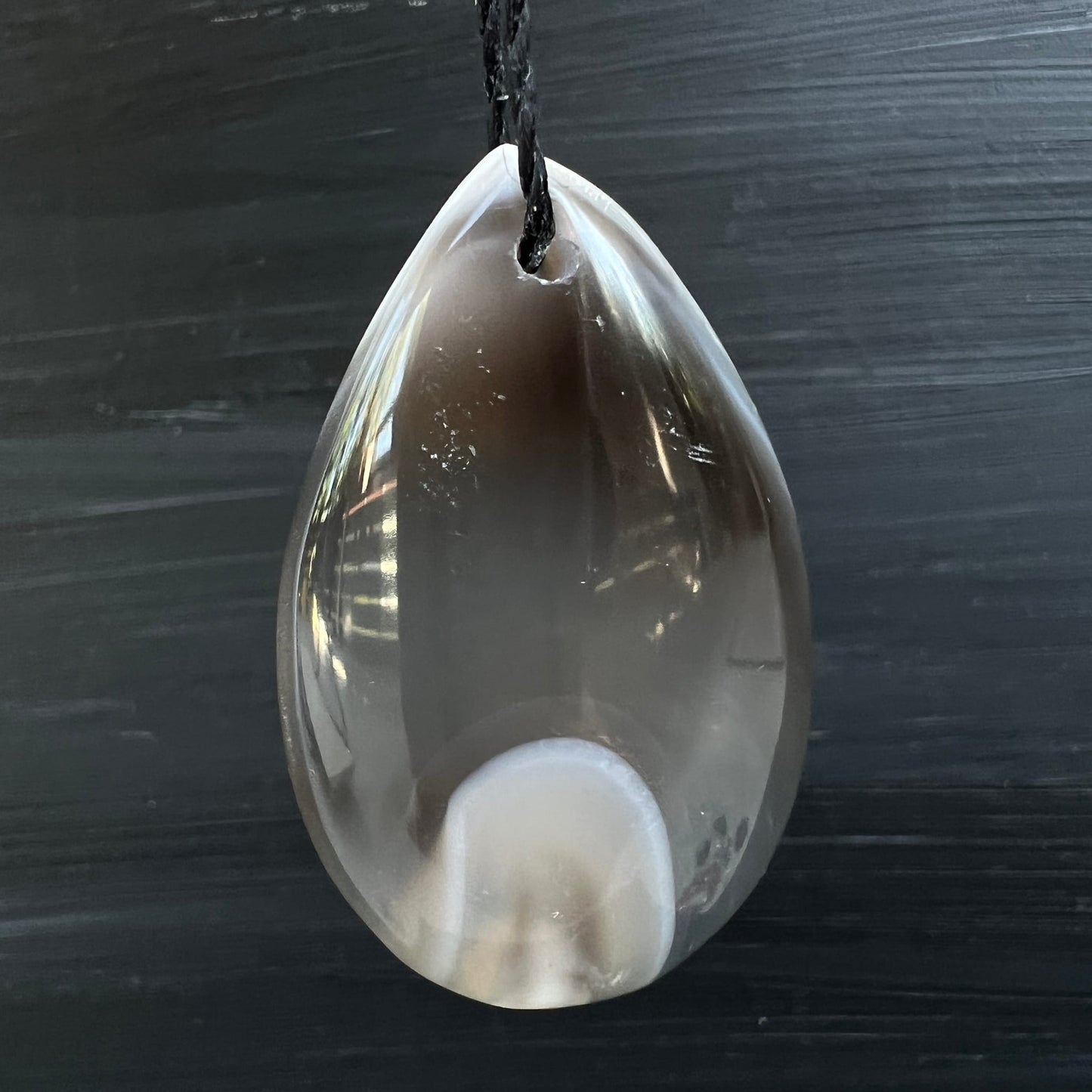 Orca Achat Tropfen | hängend | schwarzer Hintergrund | weißes Oval | transluzent | Happy Minerals