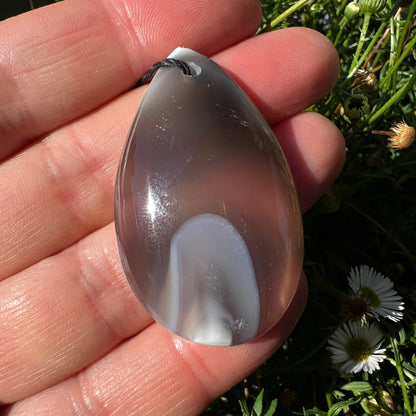 Orca Achat Tropfen | grau-weiß | in der Hand | Vorderseite | Madagaskar | Happy Minerals