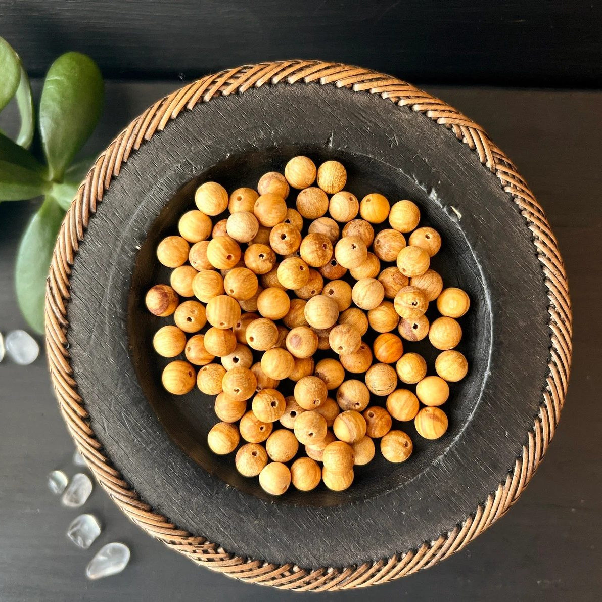 Palo Santo Kugelperlen | schwarze Schale | Wicker-Rand | grüne Pflanze | Kristalle | Happy Minerals