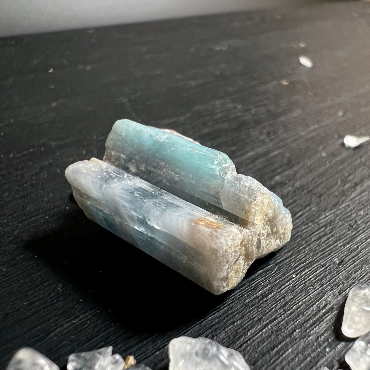 Paraiba Turmalin Rohkristall | liegend fotografiert | türkise Farbverläufe | naturbelassene Textur | Happy Minerals