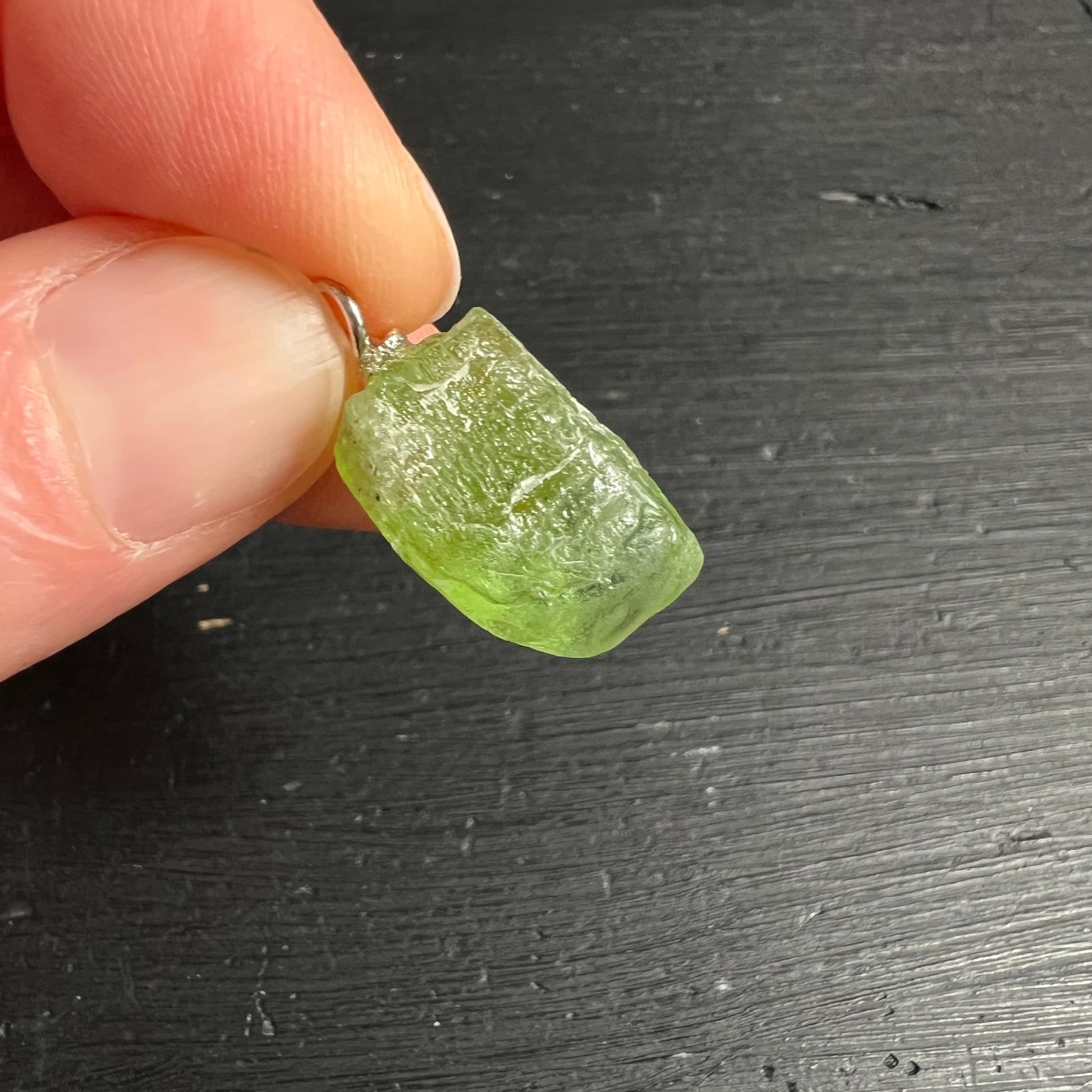 Peridot Rohstein olivgruen mit glasigem Glanz, unregelmaessige Oberflaeche, kleiner Silberoesen-Anhaenger | Happy Minerals