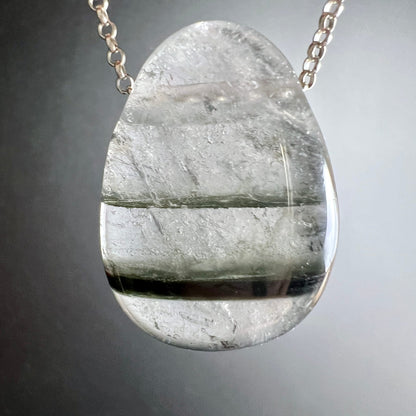 Phantomquarz Anhänger tropfenform, klares Quarz mit 3 dunkelgrauen Phantom-Schichten horizontal geschichtet, poliert | Happy Minerals