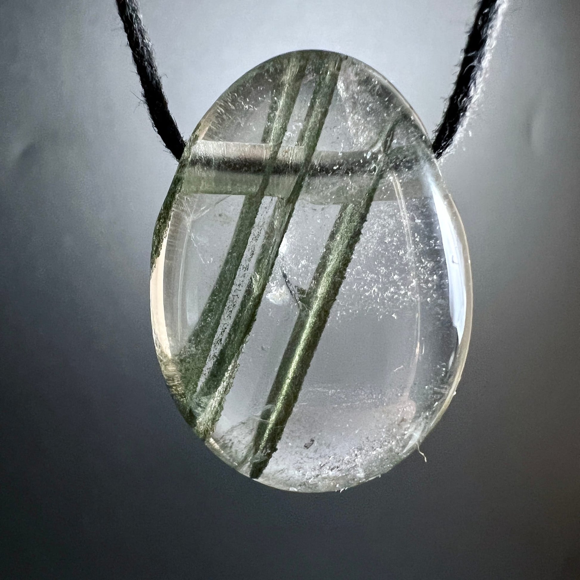 Phantomquarz hängend | schwarzes Band | grüne Phantomlinien | grauer Hintergrund | Happy Minerals