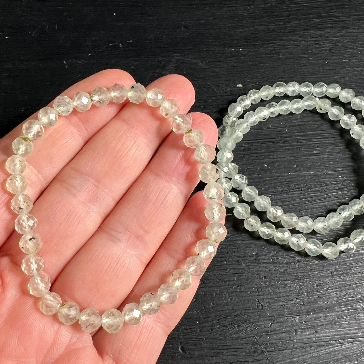 Prehnit Armband | auf Hand getragen | Größenvergleich | zarte Mintoptik | zwei weitere Armbänder im Hintergrund | Happy Minerals